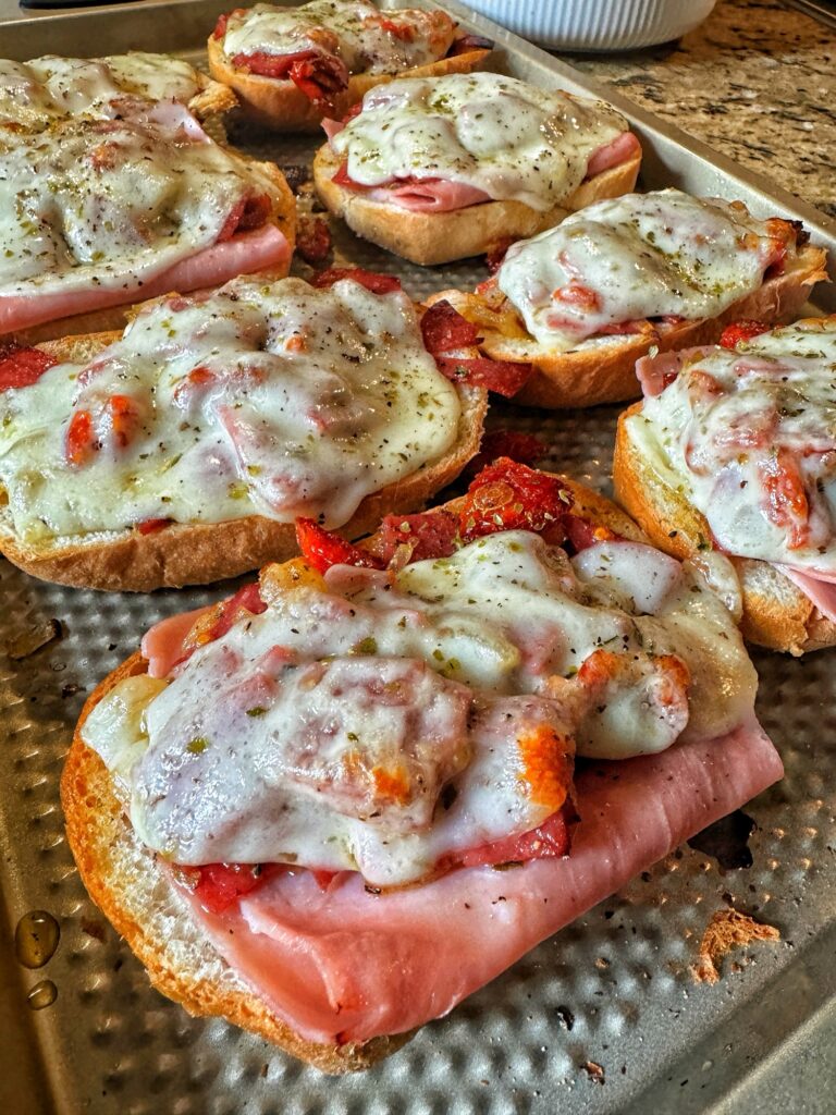 The cheese has melted on to the meat and sun dried tomatoes on the bread