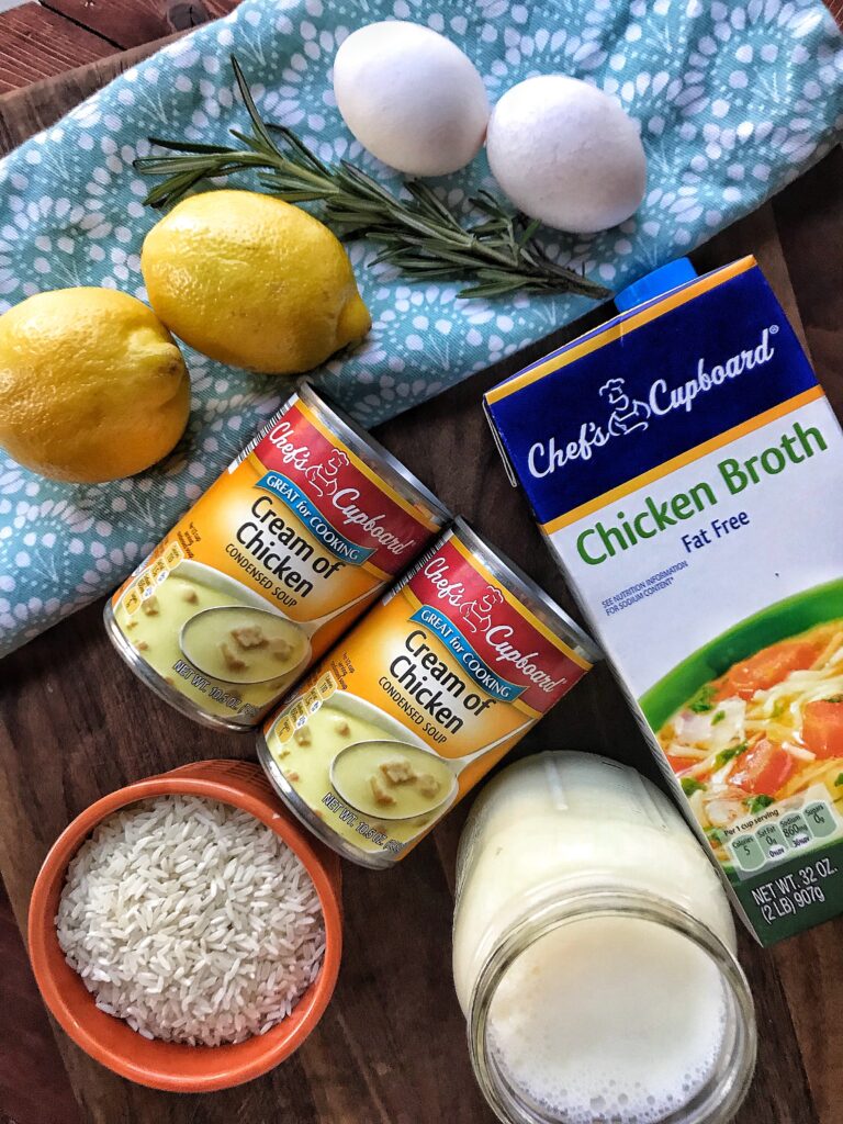 The ingredients for the Greek chicken and lemon soup spread out on a table, including cream of chicken soup, chicken broth, lemons, and rice