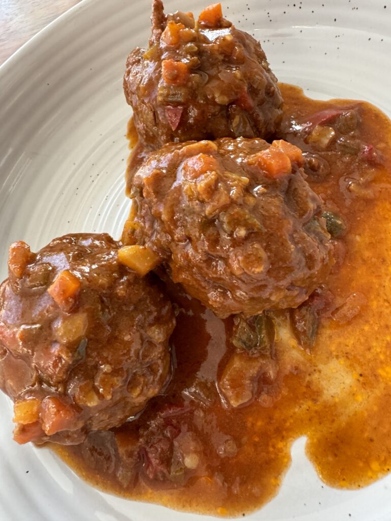 The finished Italian meatballs on a plate covered in sauce