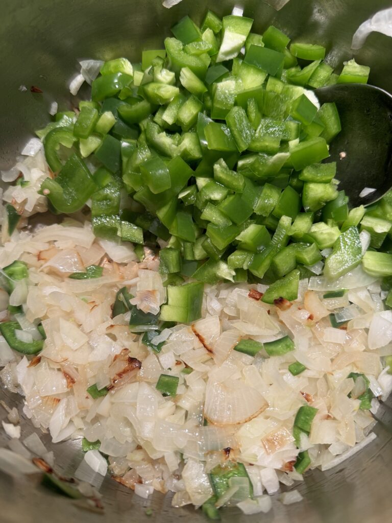 Diced green peppers and onions in a pot