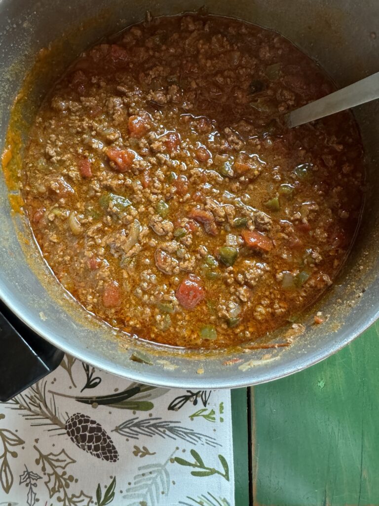 Cooked chili in a pot with a ladle in it