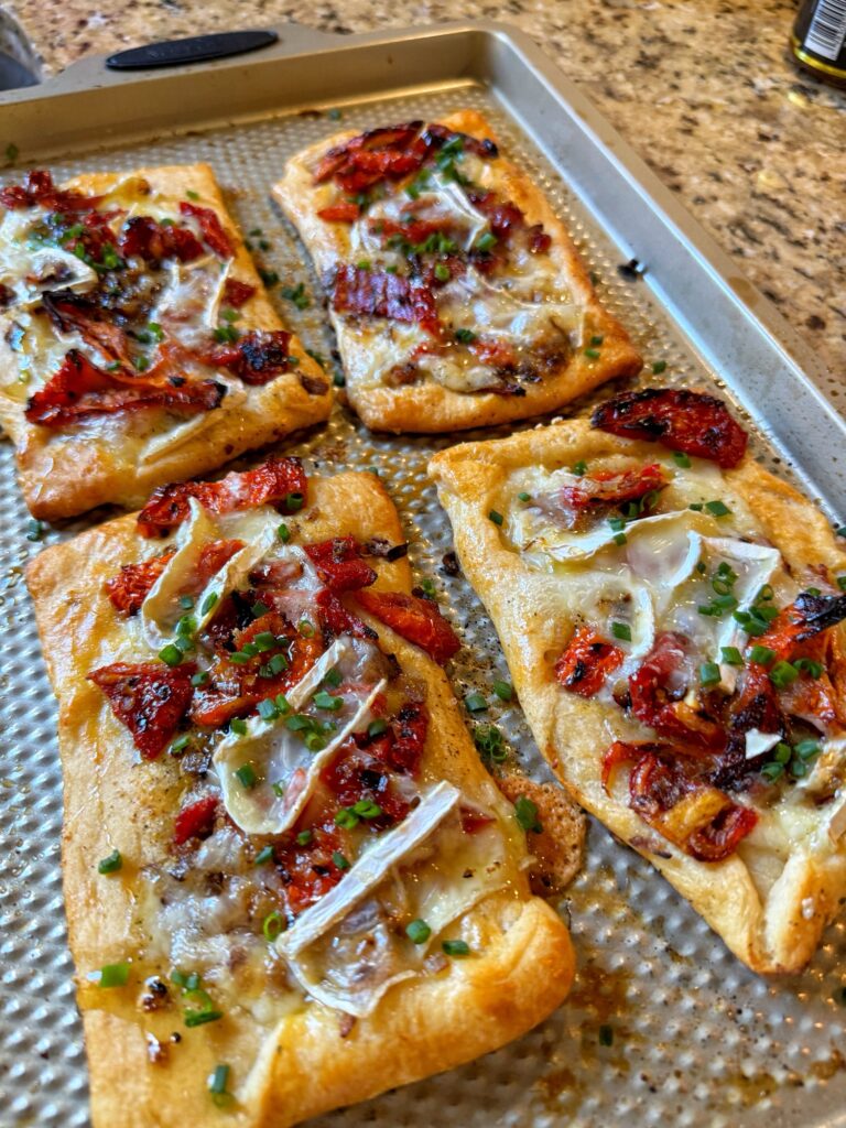 The finished sun dried tomato and brie tarts on a baking sheet