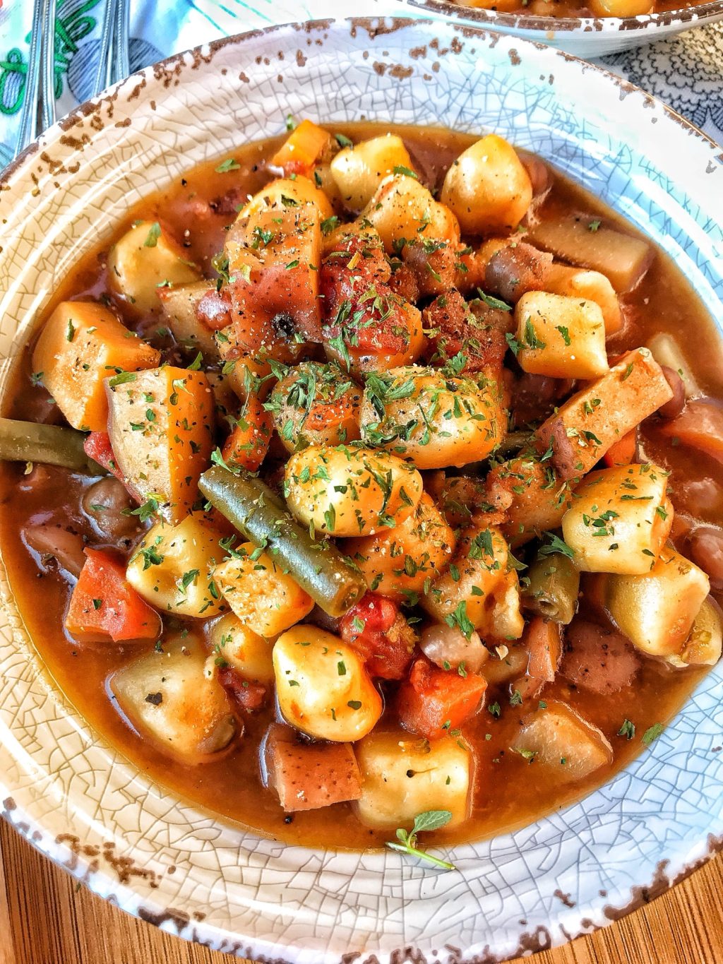 An overhead shot of the finished minestrone soup with potato dumplings in a bowl
