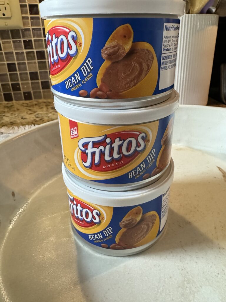 Three cans of Fritos bean dip stacked on top of one another