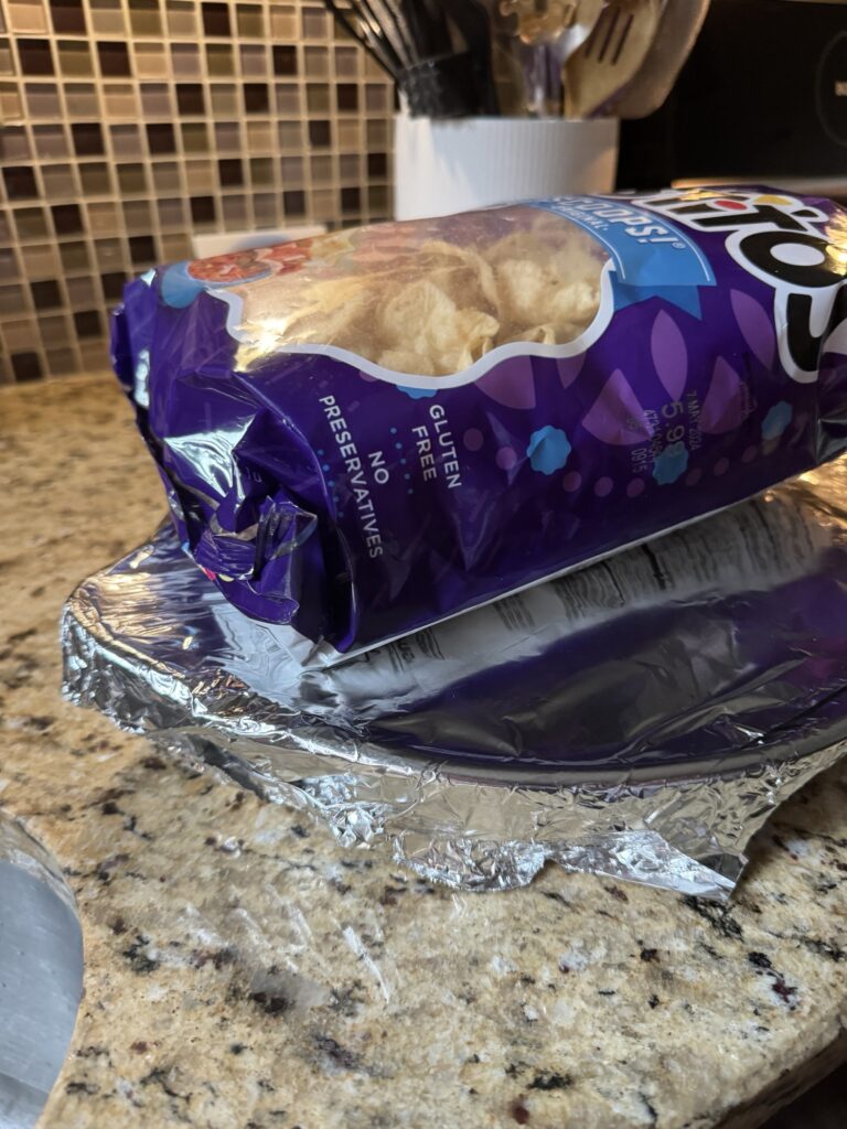 A bag of Tostitos Scoops chips on the counter