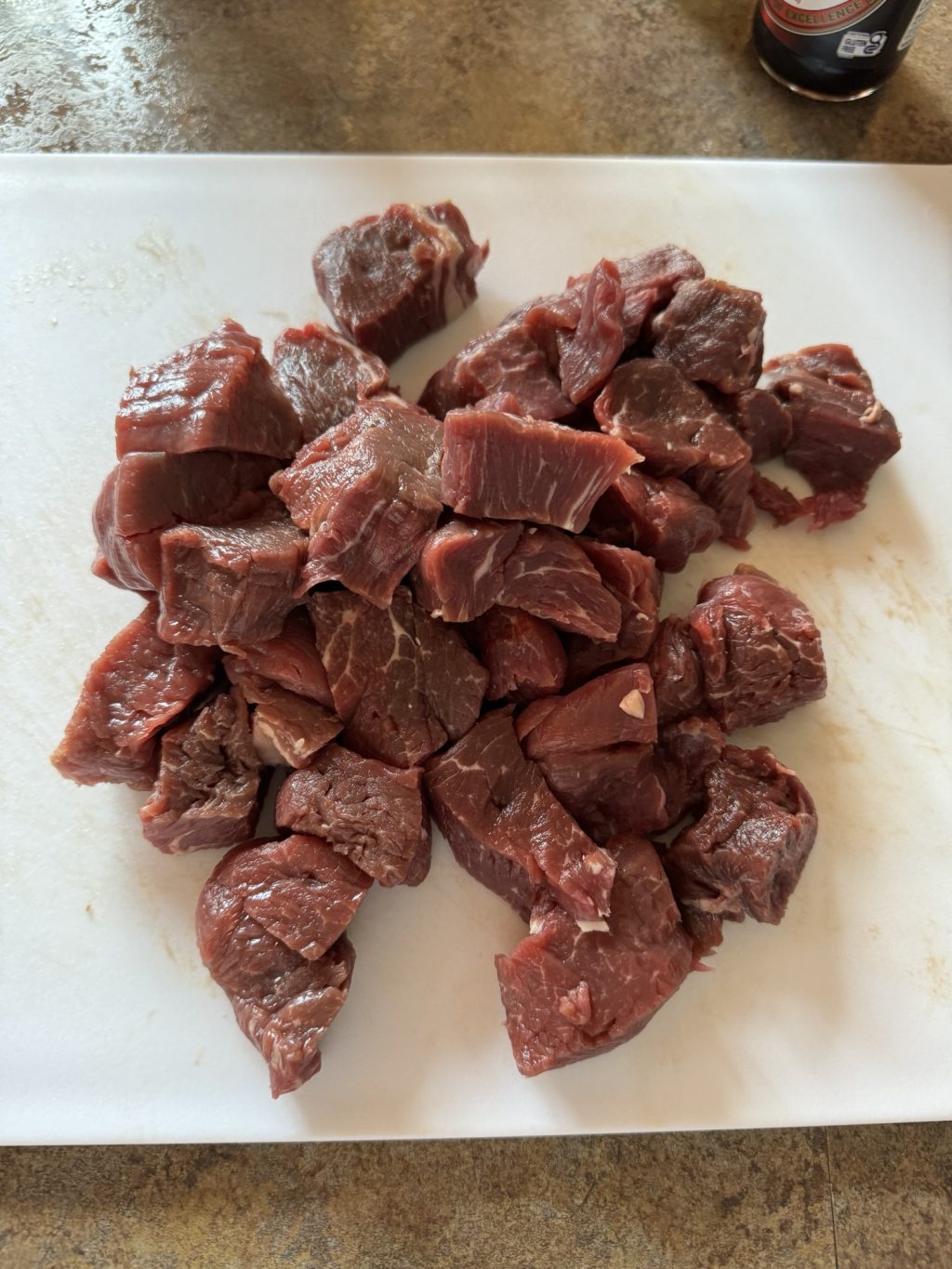 Raw beef chopped into cubes on a cutting board