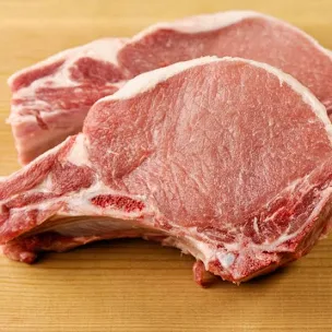 Two raw pork chops.