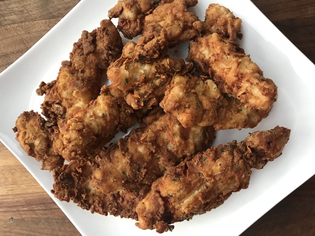 Pieces of fried chicken breasts on a white plate