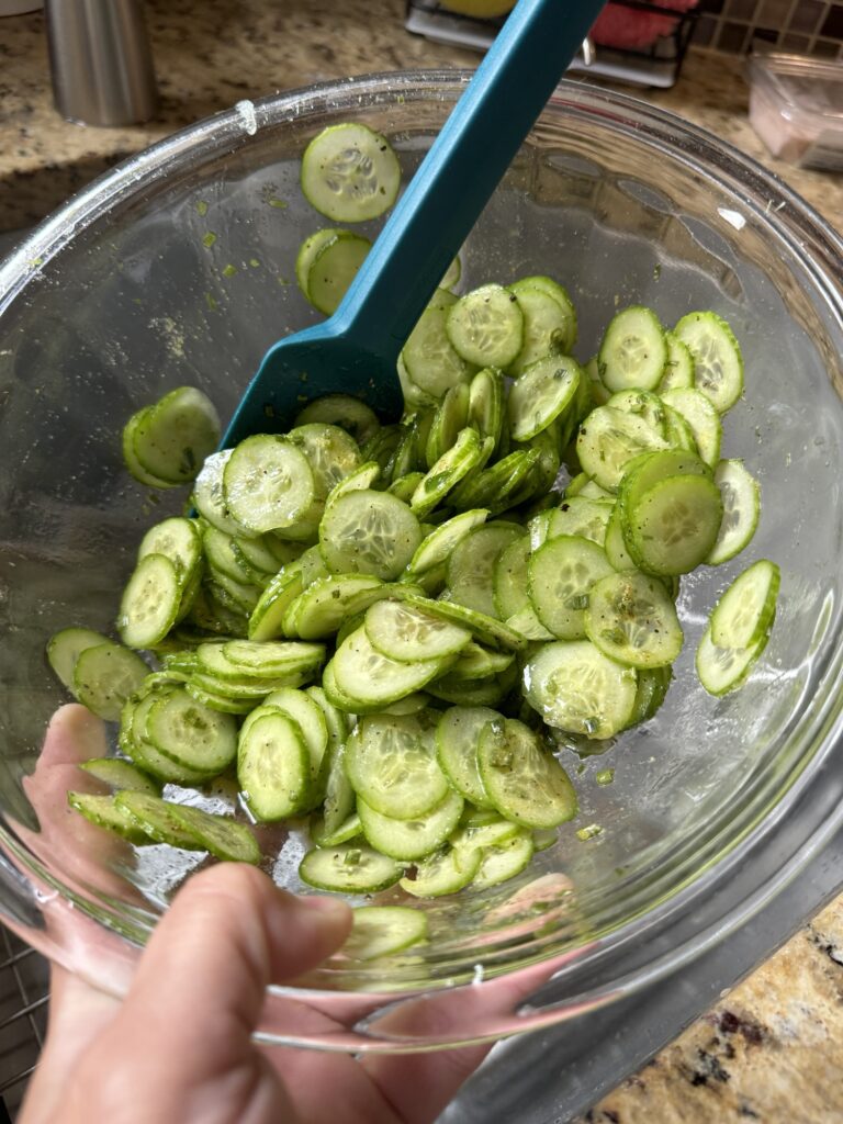 A bowl filled with sliced, marinated cucumbers