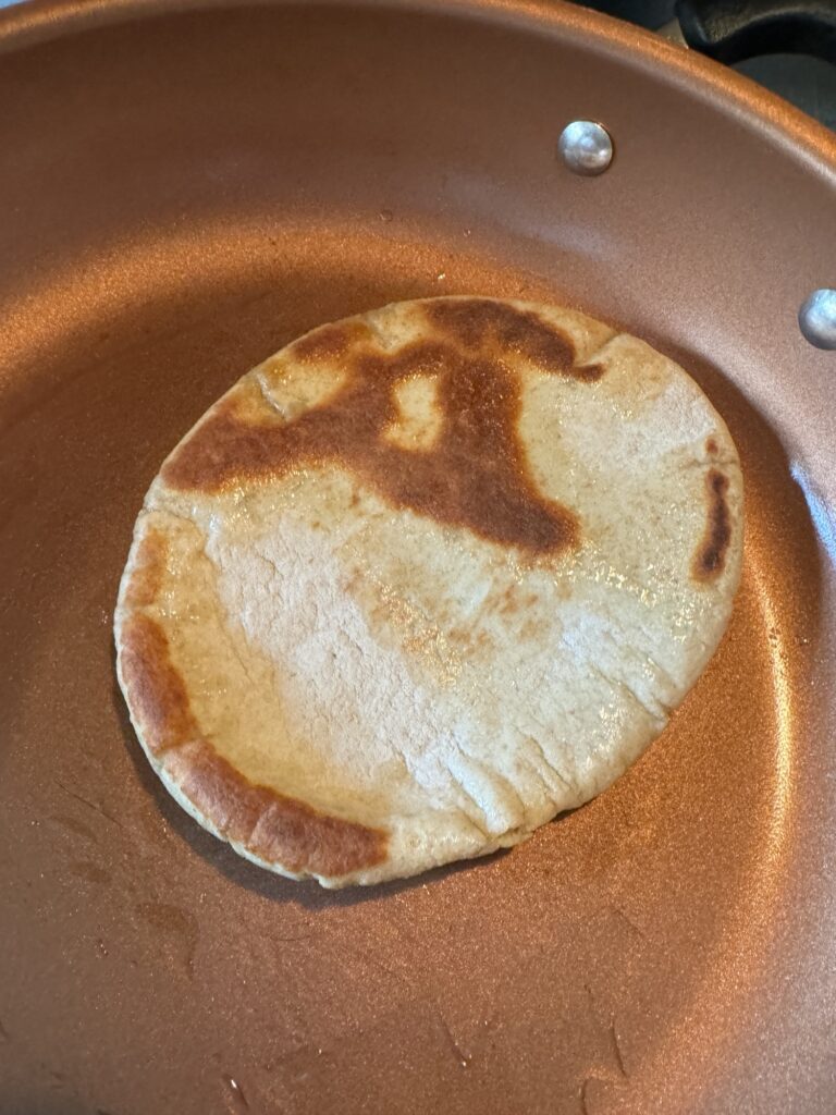 A pita toasting in a pan