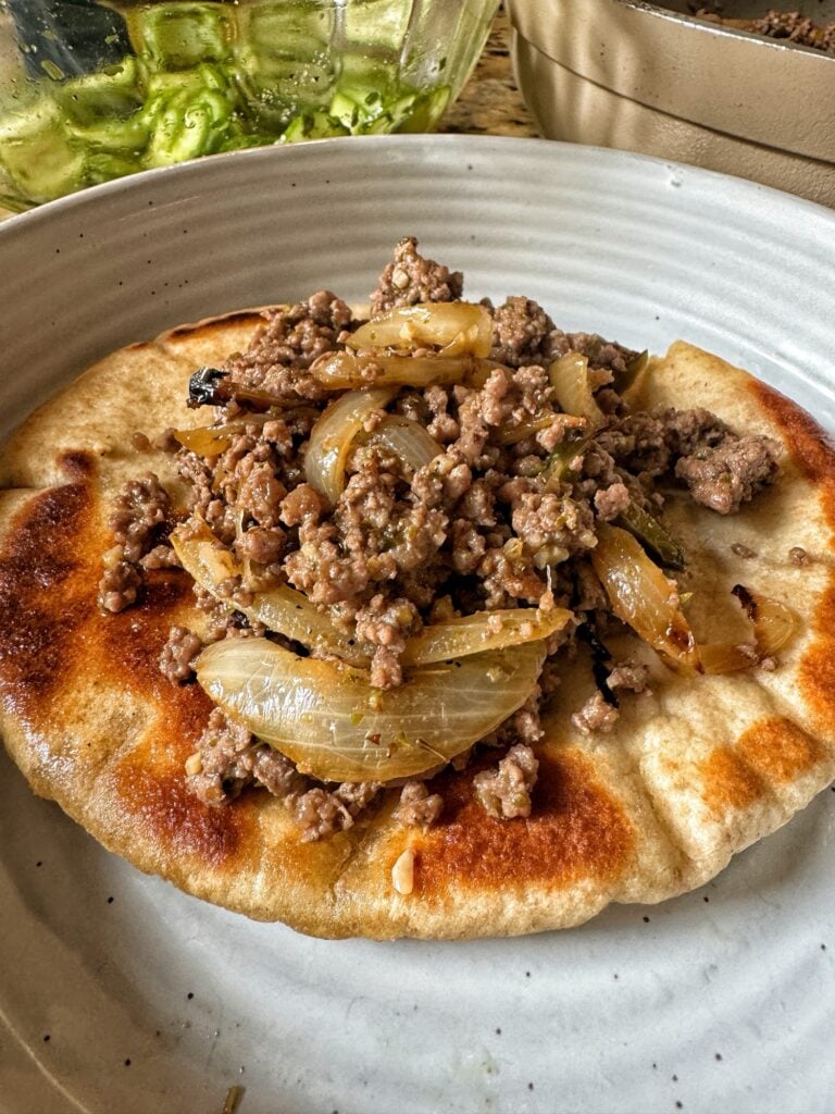 Ground meat and cooked onions on a pita