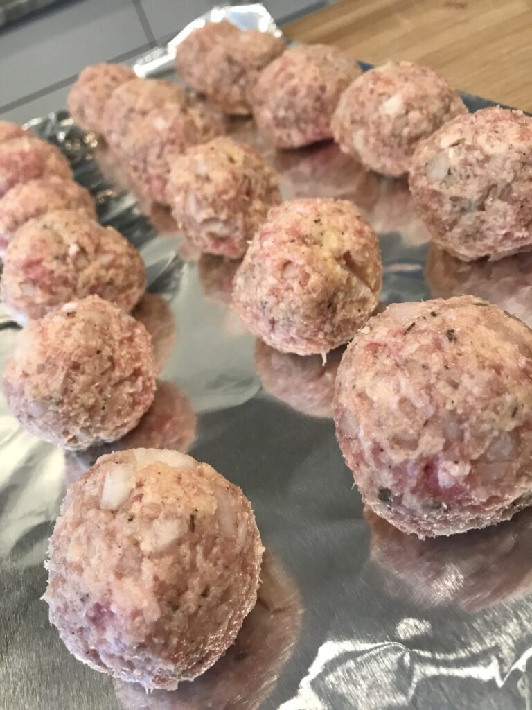 Raw meatballs on a baking dish