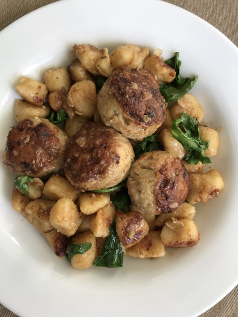 Meatballs with gnocchi and greens in a bowl