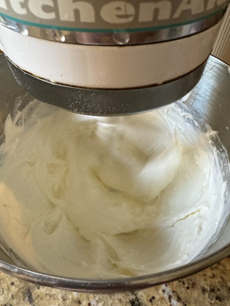 Cream cheese and sour cream in a metal mixing bowl