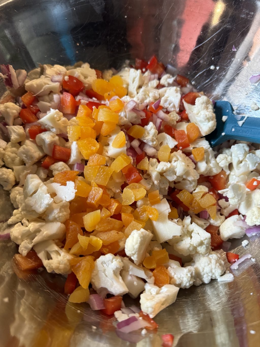 The diced vegetables and dried apricot bits mixed in a metal bowl