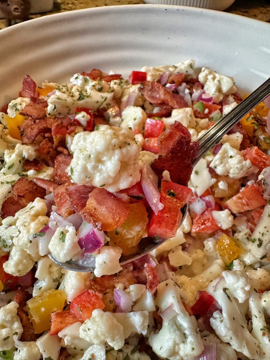 A close up of a spoonful of the Cauliflower Crunch Salad