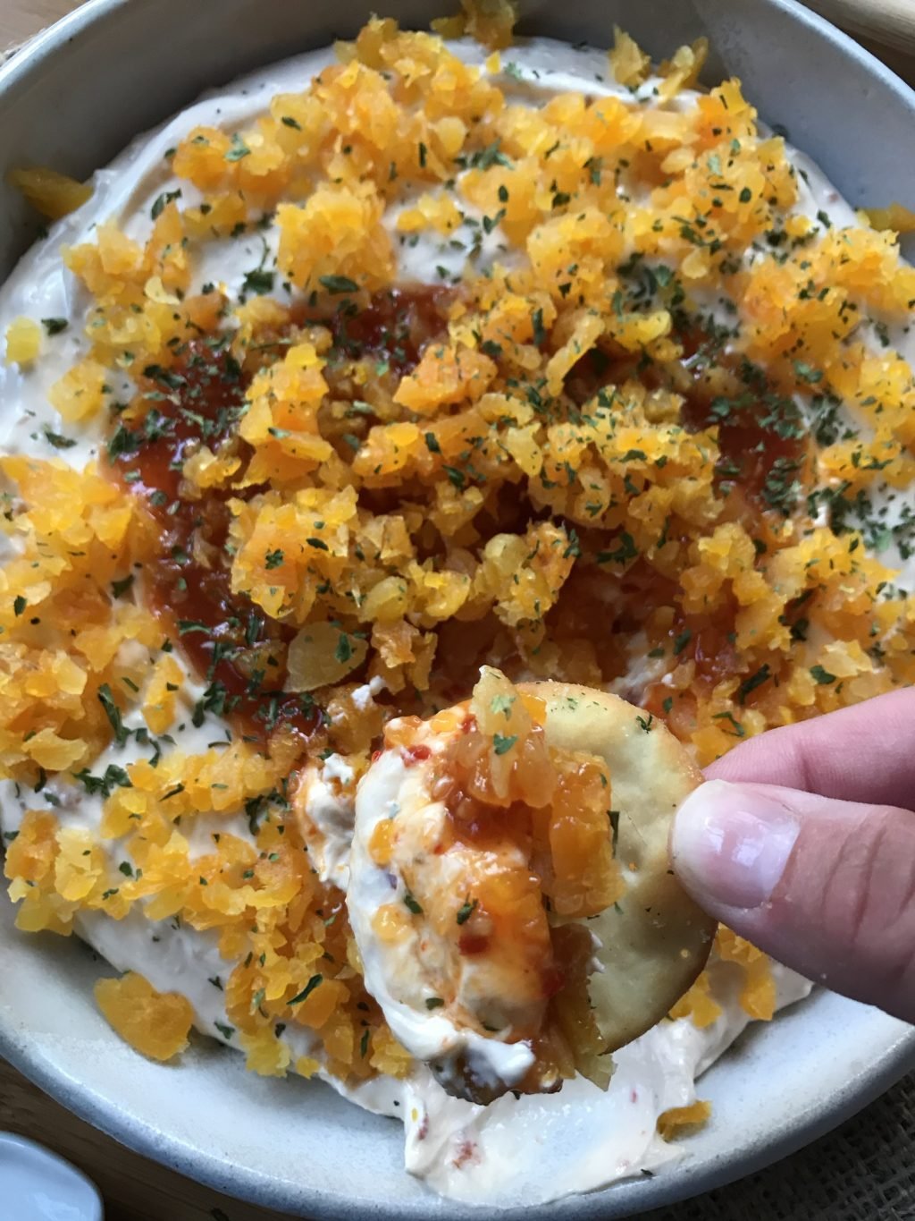 The finished apricot and goat cheese with sweet chili dip on a pita cracker