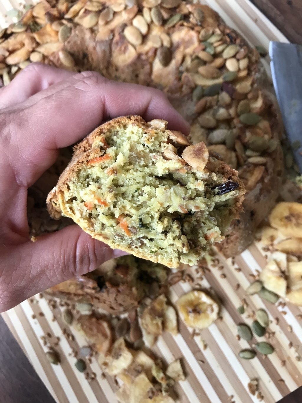 A slice of breakfast bread being held above the rest of it.