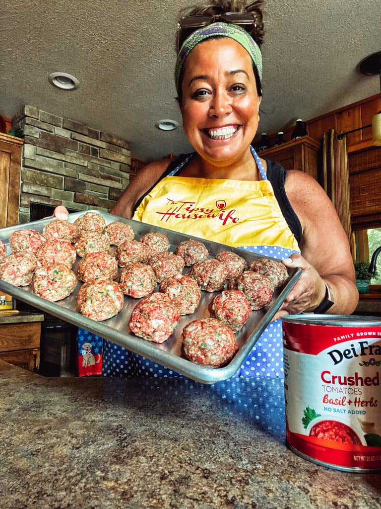 Me holding a tray of big meatballs.