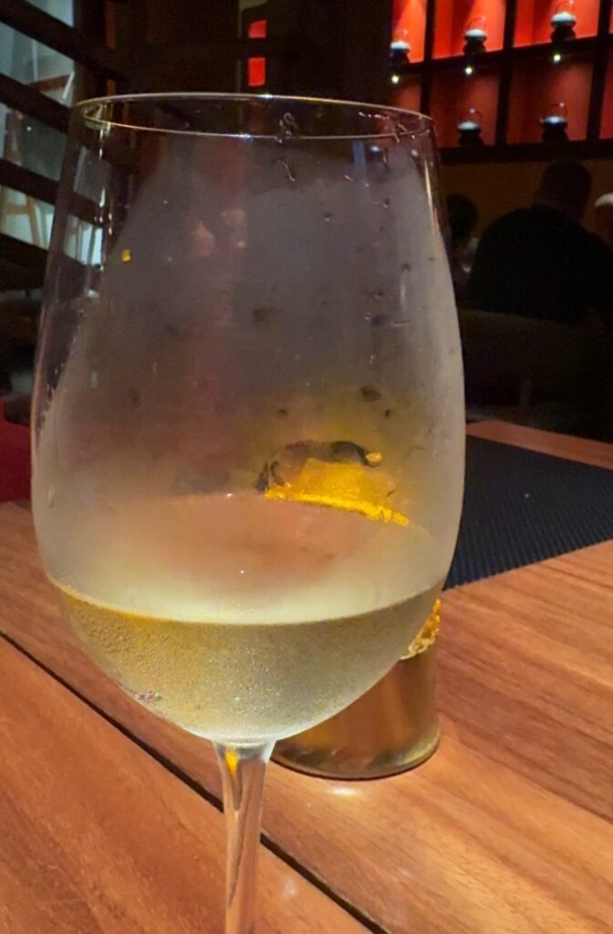 A glass of white wine on a wooden table
