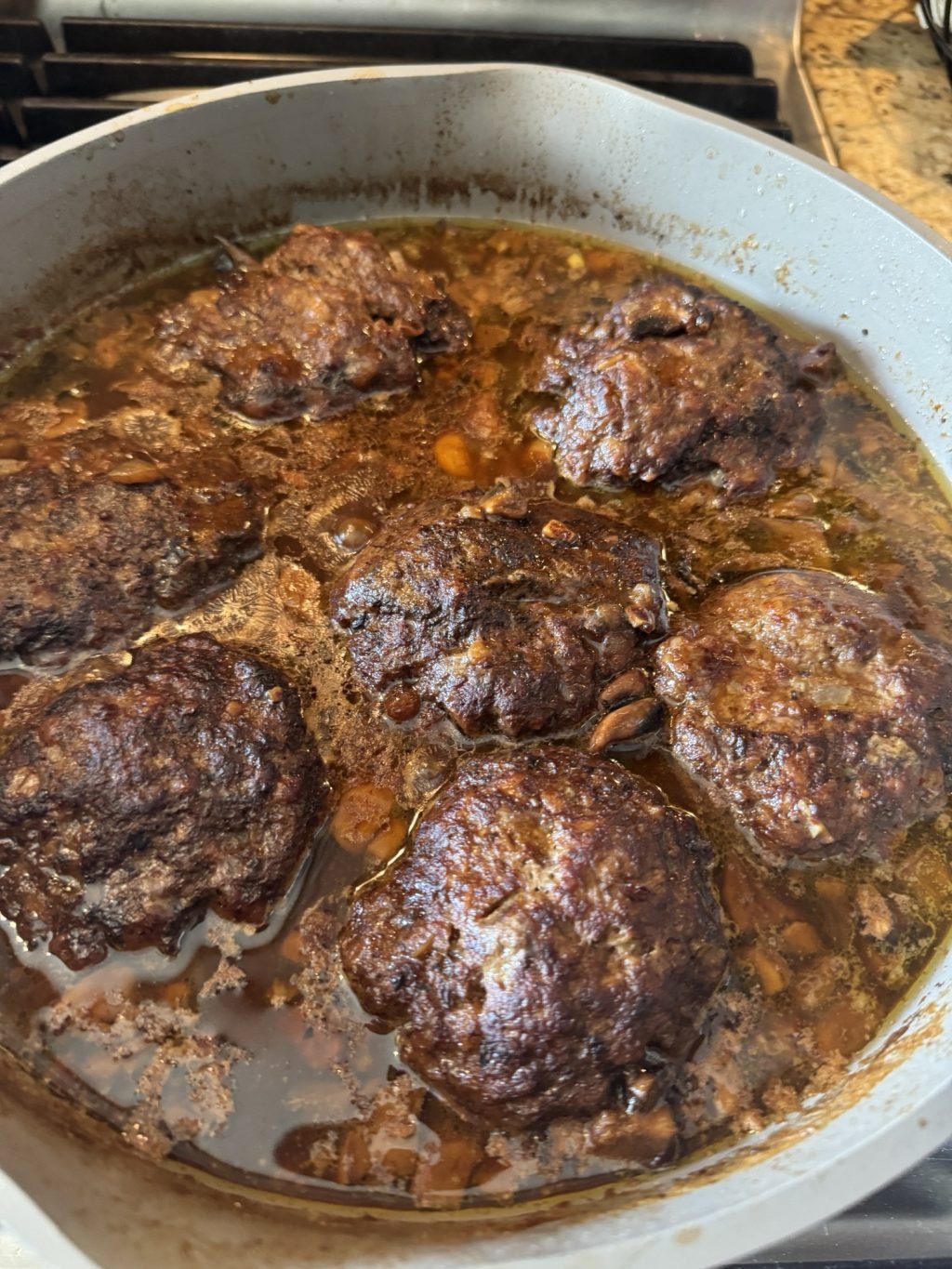 Salisbury Steak patties simmering in gravy