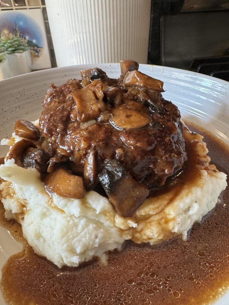 Salisbury Steak over mashed potatoes topped with mushroom gravy