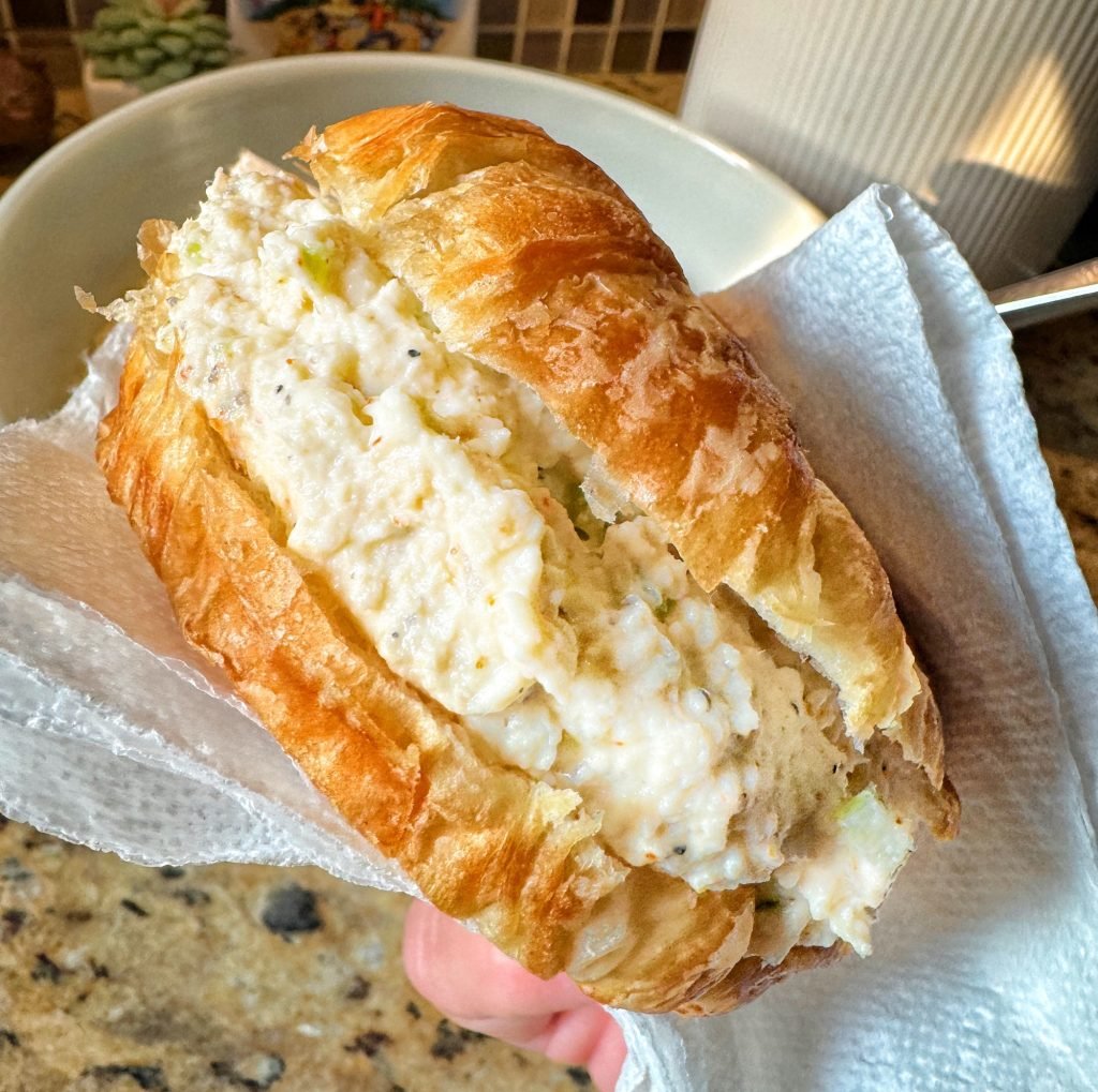 A close up shot of a chicken salad croissant sandwich