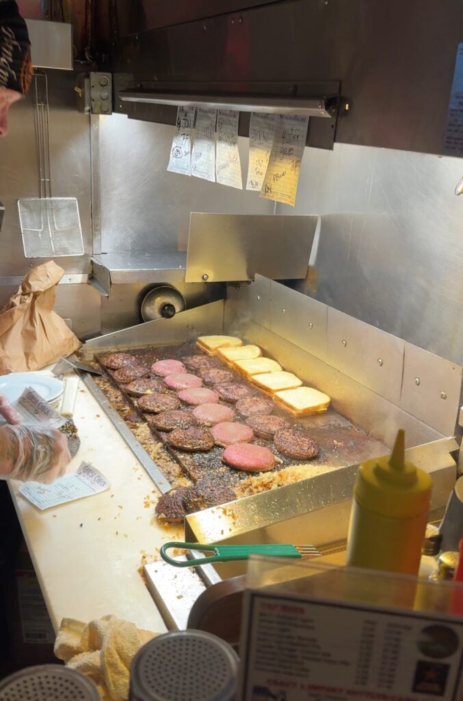 Burgers cooking on a grill behind the bar at Matt's.