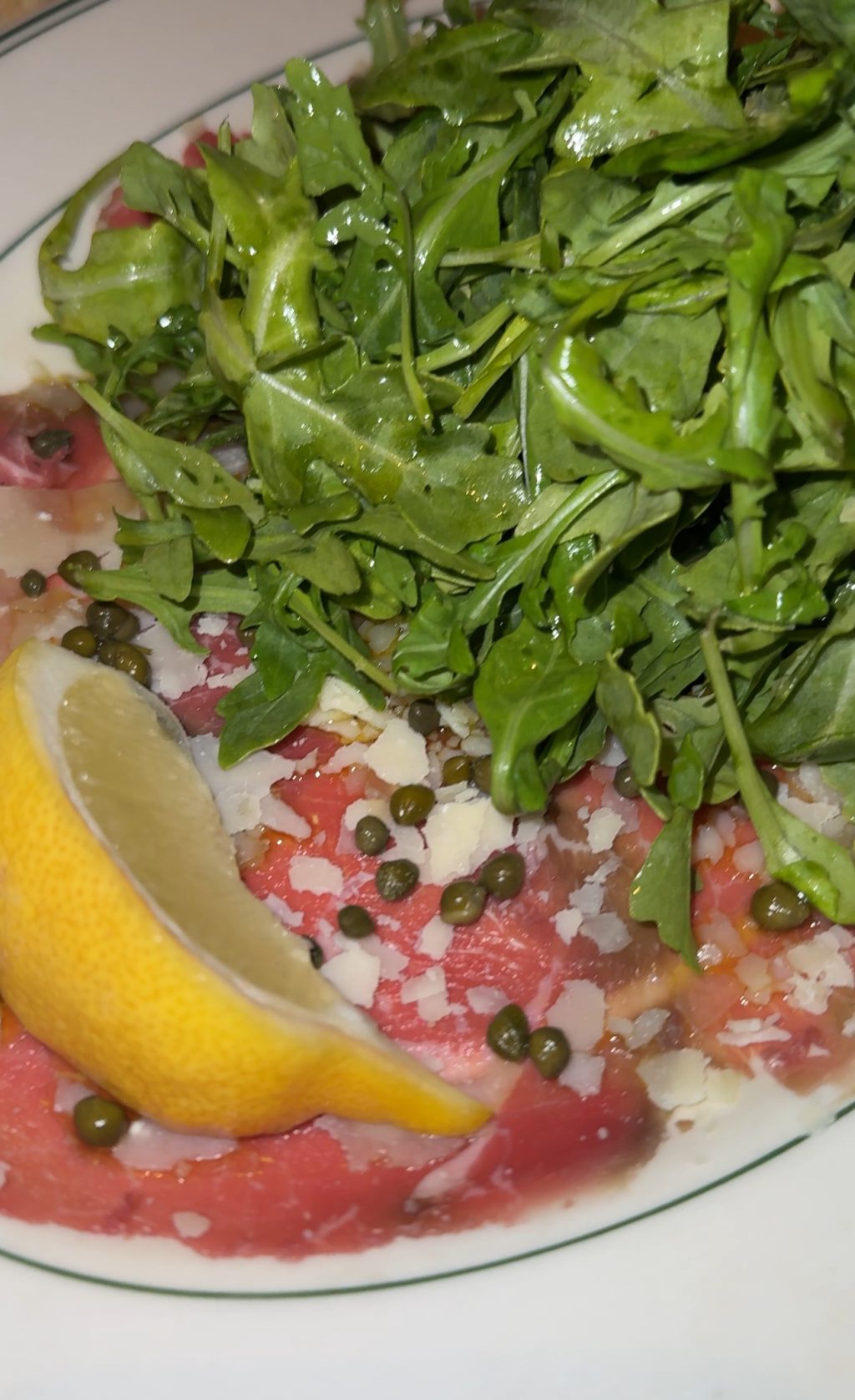 Beef carpaccio with lemon and greens.