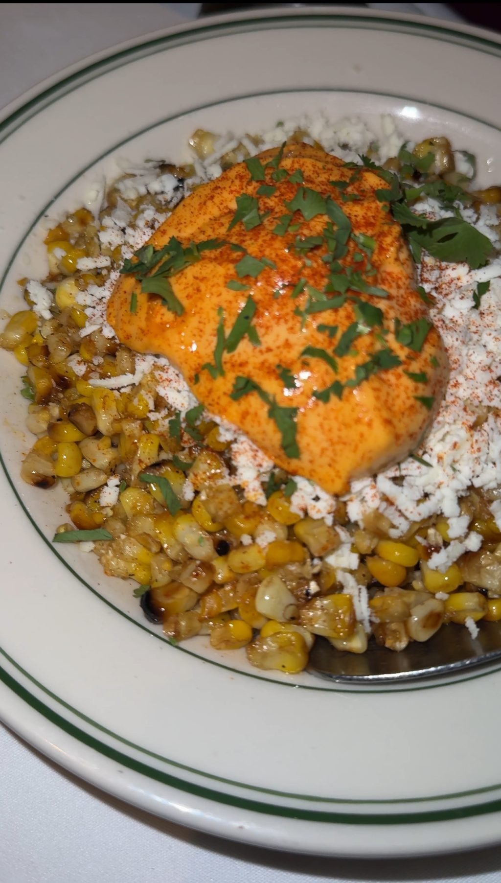 Corn elotes with cheese and orange sauce.