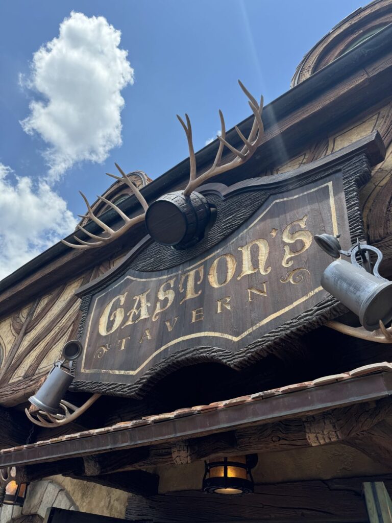 The exterior of Gaston's Tavern with a sign with the restaurant's name and deer antlers above it.