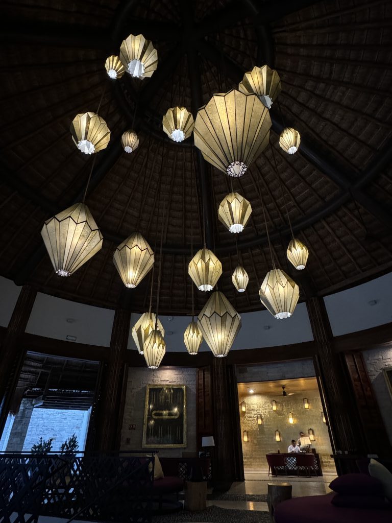 Chandeliers of different sizes hanging from the ceiling in the hotel lobby.