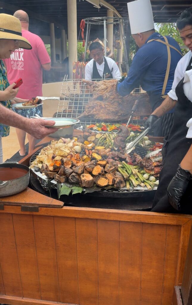 People lining up to get food from the poolside grill.