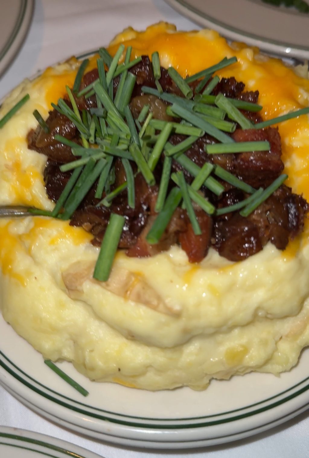 Loaded mashed potatoes with cheese and green onion and mushrooms.