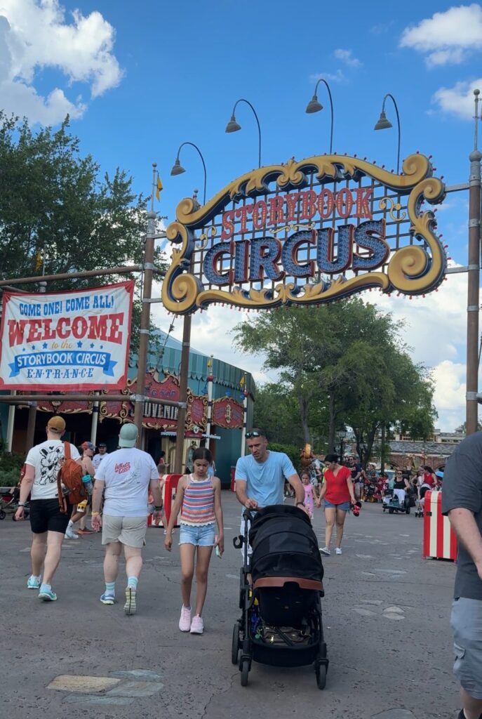 The entrance to the Storybook Circus area of the Magic Kingdom. There is a sign that says "Storybook Circus" next to a banner that reads "Come One! come All! Welcome."