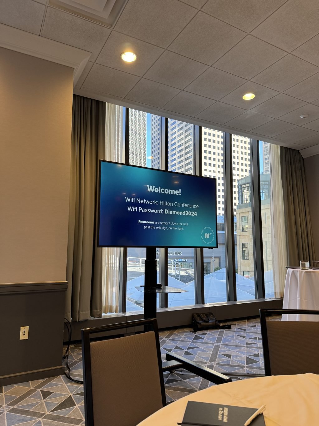 An image of conference room in the hotel with a screen welcoming us.