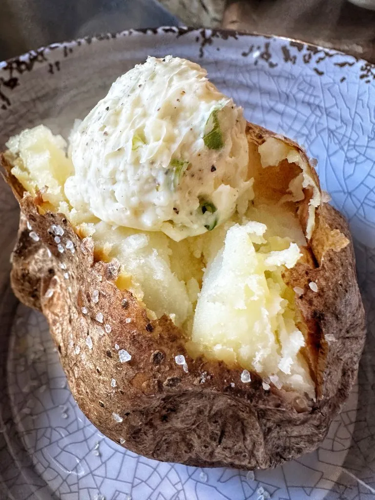 A baked potato with a butter ball on top.