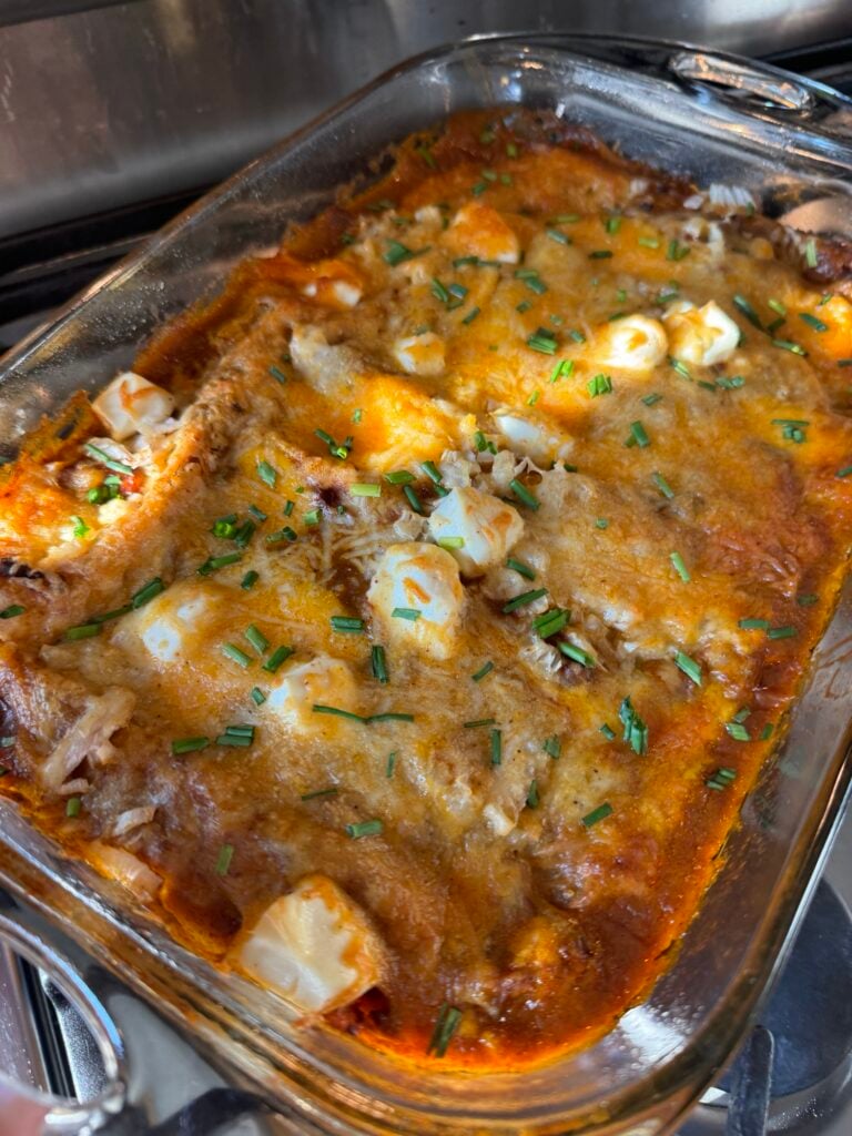 Chili cheese dip enchiladas in a glass baking dish.
