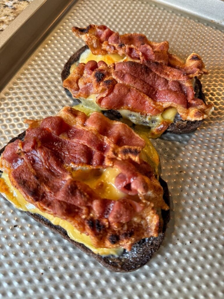 Open faced sandwiches with bacon over melted cheese and pineapple.