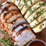 Sliced pork next to Czech dumplings and marinade.
