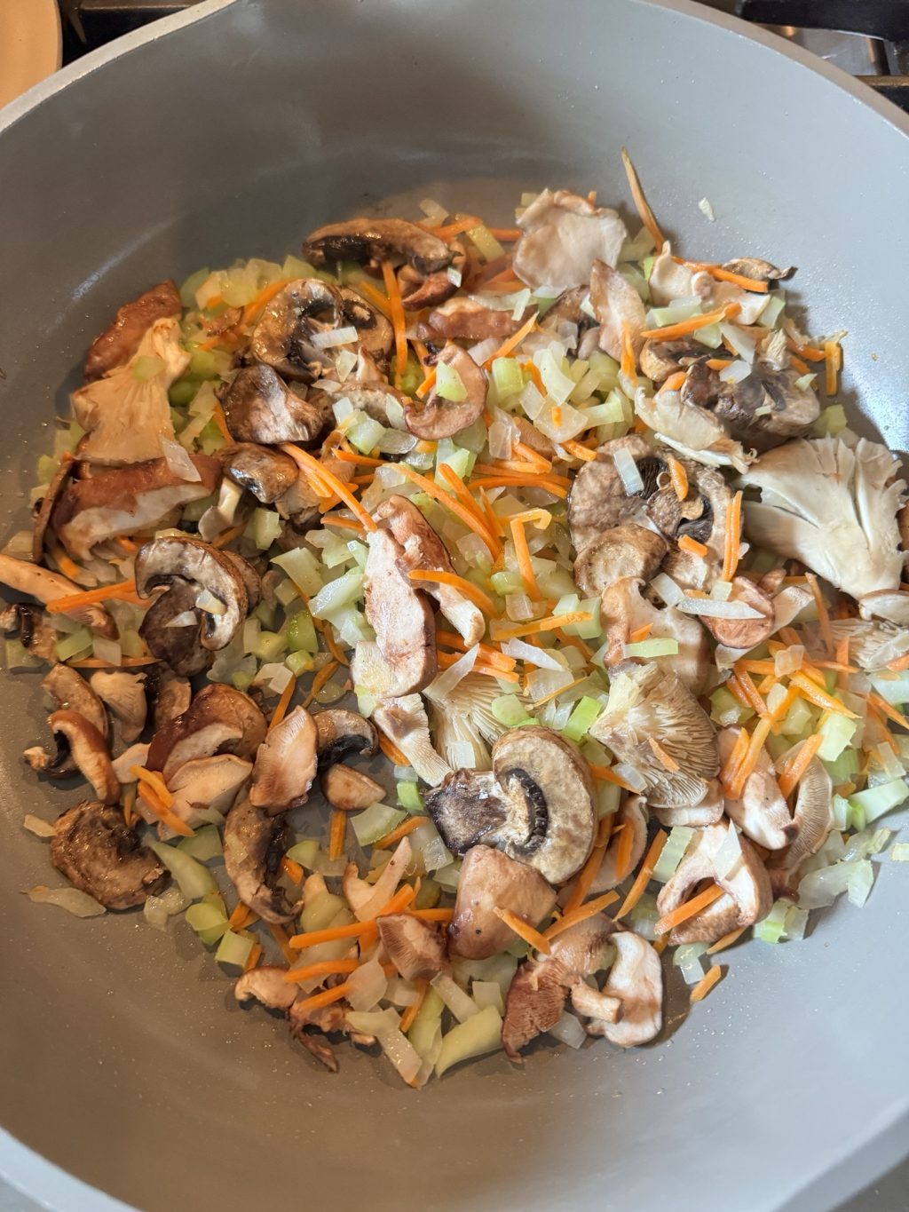 A blend of diced celery, onions, mushroom, and carrots in a pot.