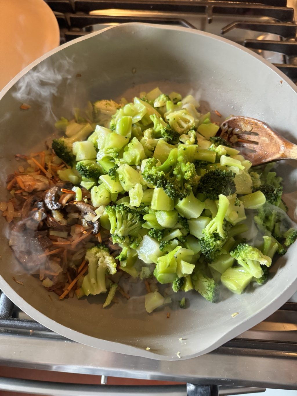 Vegetables, primarily broccoli, cooking in a pot.