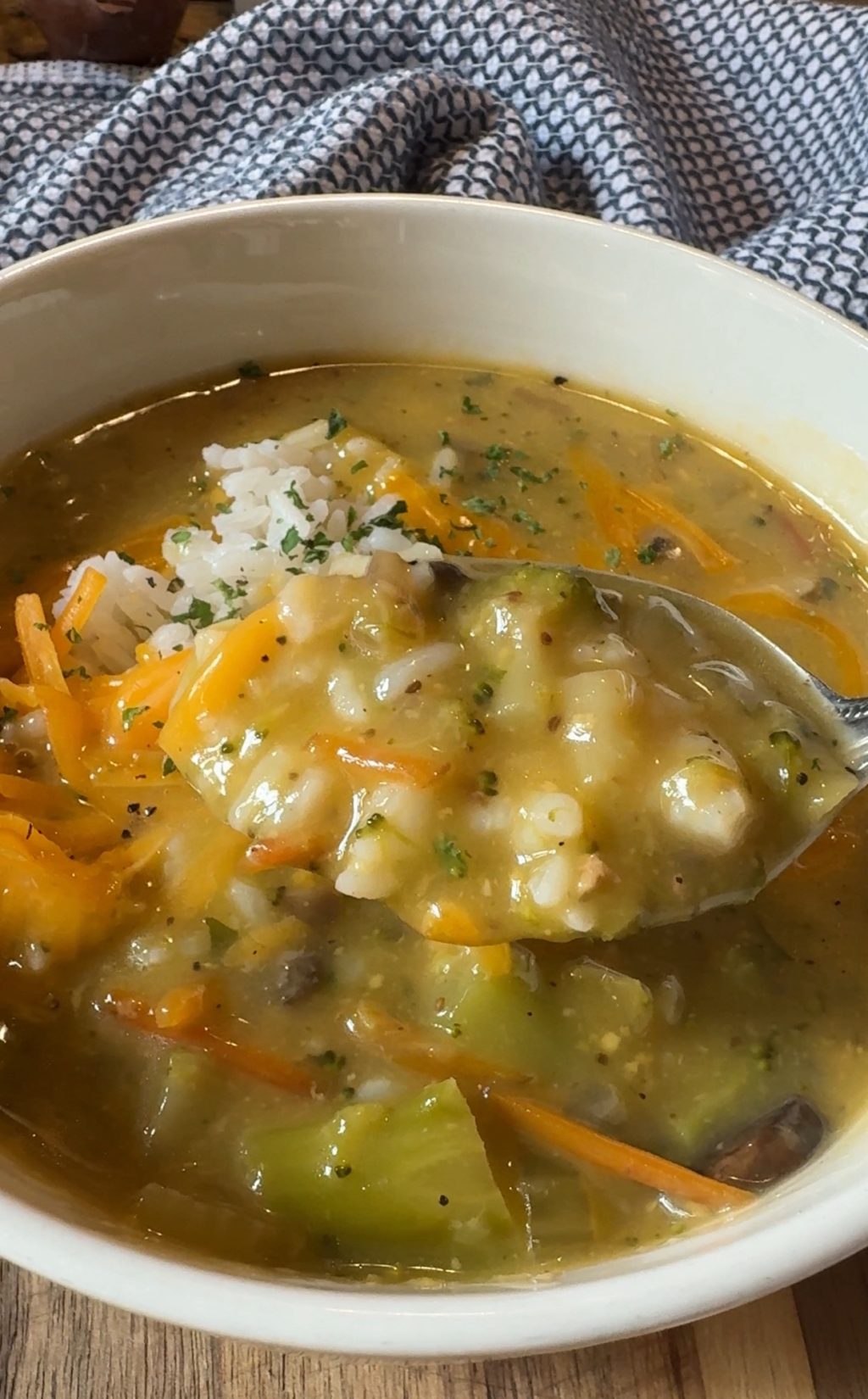 Another angle of a spoon of cheddar broccoli soup.