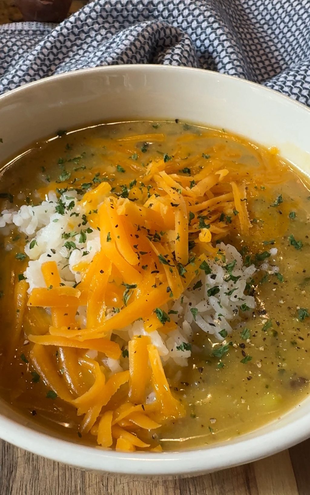 Broccoli cheddar soup with rice and shredded cheddar on top.