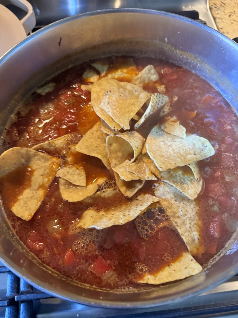 Tortilla chips in the soup in the pot