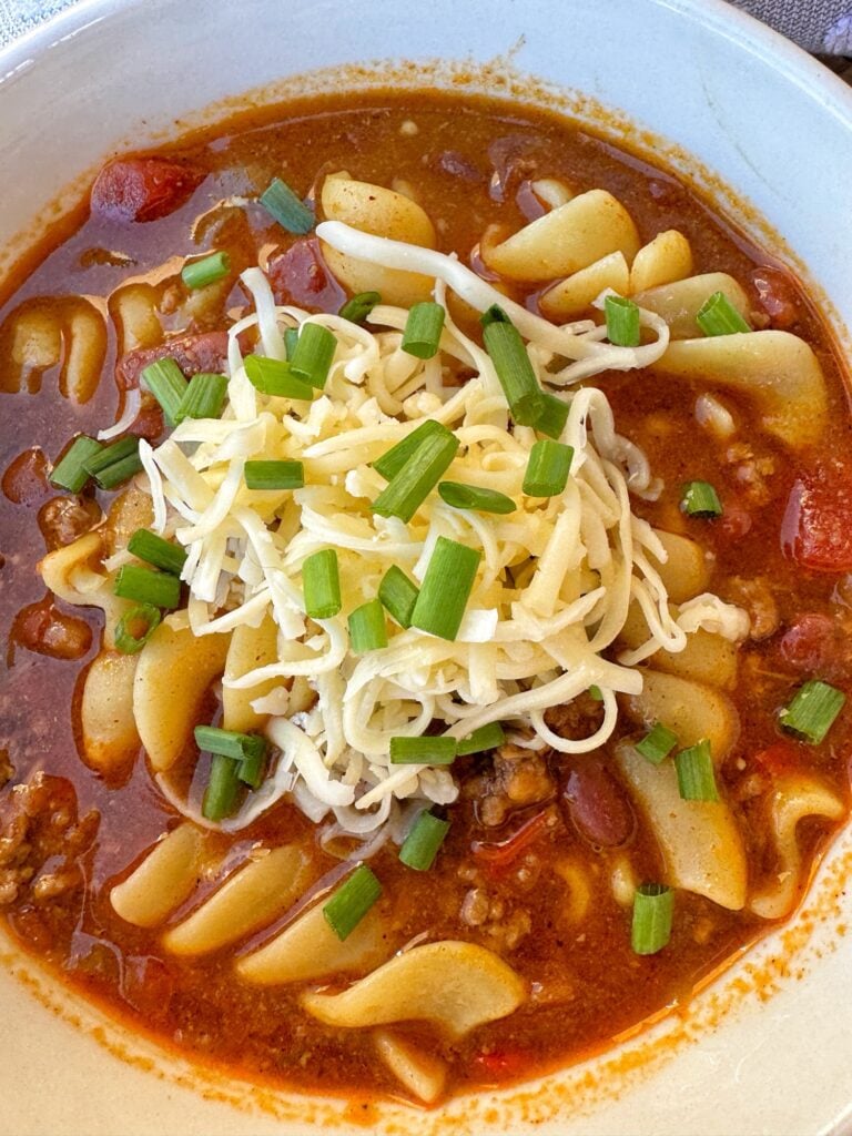 A close up shot of a bowl of chili mac soup
