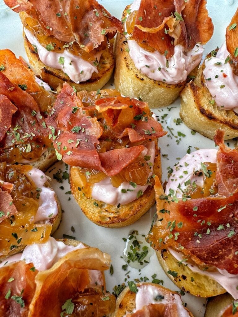 Cranberry cheese toasts topped with crispy prosciutto and honey.