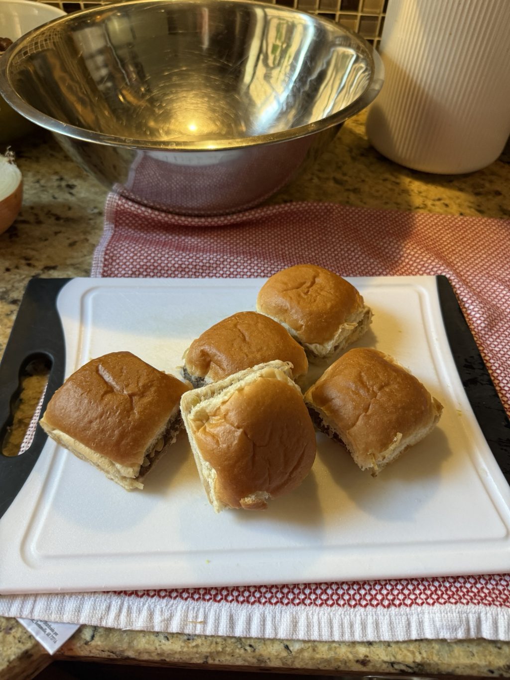 Five White Castle sliders on a white cutting board.