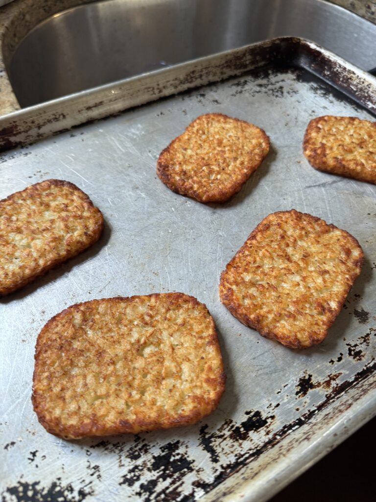 Hash browns spread on a baking pan.