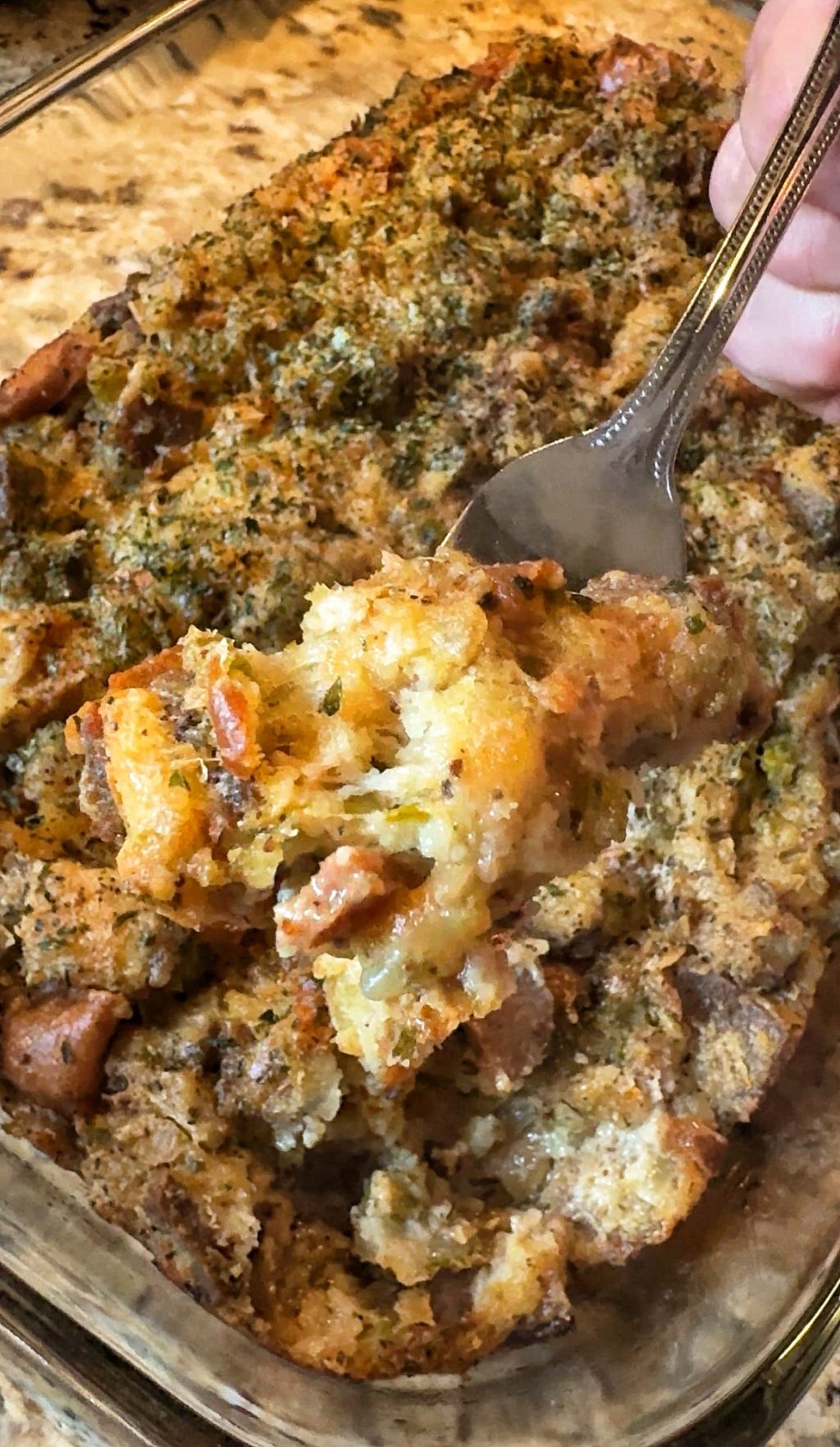 A forkful of White Castle stuffing being taken from the rest in the baking dish.